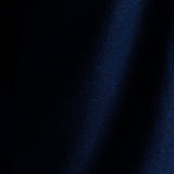 A close-up of dark navy blue textured fabric with a fine woven pattern and soft vertical folds.