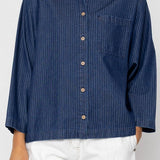 Person wearing a blue striped shirt with a white background