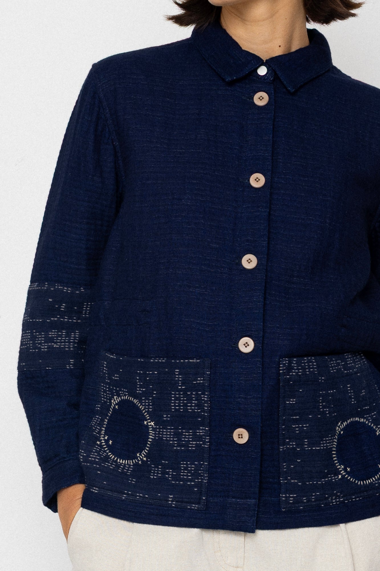 Navy blue jacket with button details on a white background