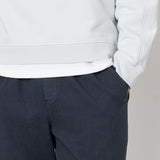 Light gray hoodie and dark gray pants on a neutral background