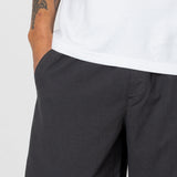 Person wearing black pants and a white shirt on a plain background