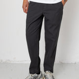 Person wearing black pants and gray sneakers on a white background