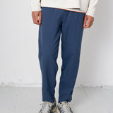 Person wearing blue pants and a cream sweater on a white background