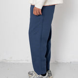 Person wearing blue pants and gray sneakers on a white background