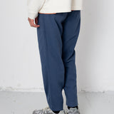 Person wearing blue pants and a white top on a white background