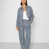 Person wearing a striped blue denim outfit with a white background