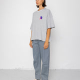 Person wearing a light gray oversized t-shirt and pants on a white background