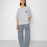 Person wearing a gray oversized t-shirt and pants on a white background