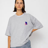 Person wearing a gray t-shirt with a small colorful logo on a white background