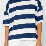 Person wearing a blue and white striped T-shirt on a plain background