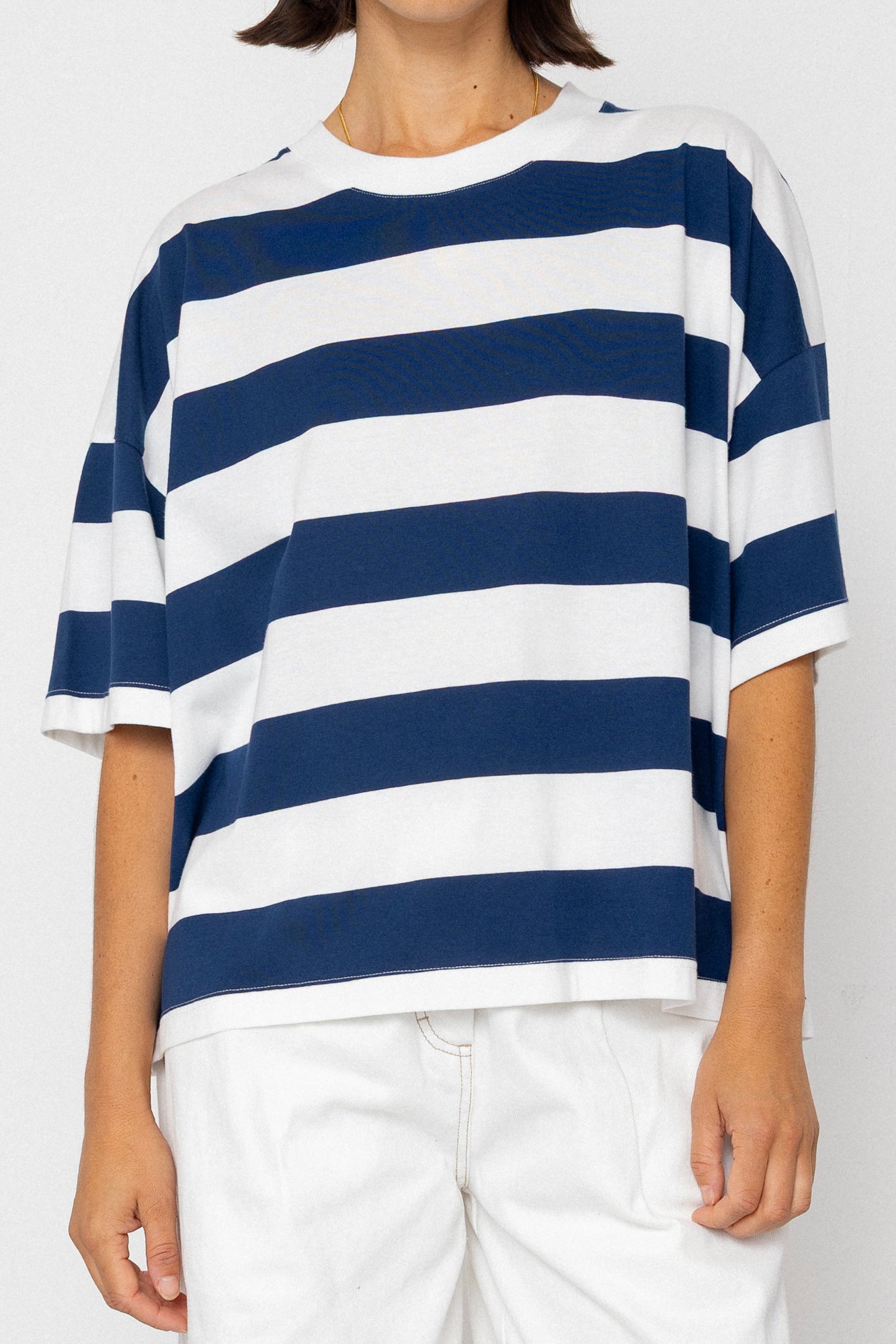 Person wearing a blue and white striped T-shirt on a plain background