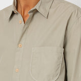 Close-up of a beige shirt with a pocket on a plain background