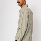 Man wearing a beige shirt against a white background