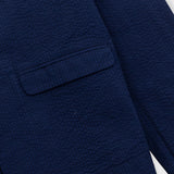 Close-up of a navy blue textured blazer on a white background