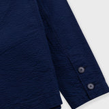 Close-up of a navy blue shirt with buttons on a white background