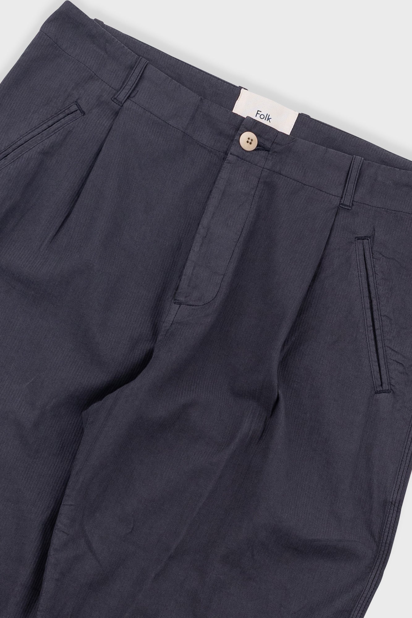 Navy pants with a visible brand label on a white background