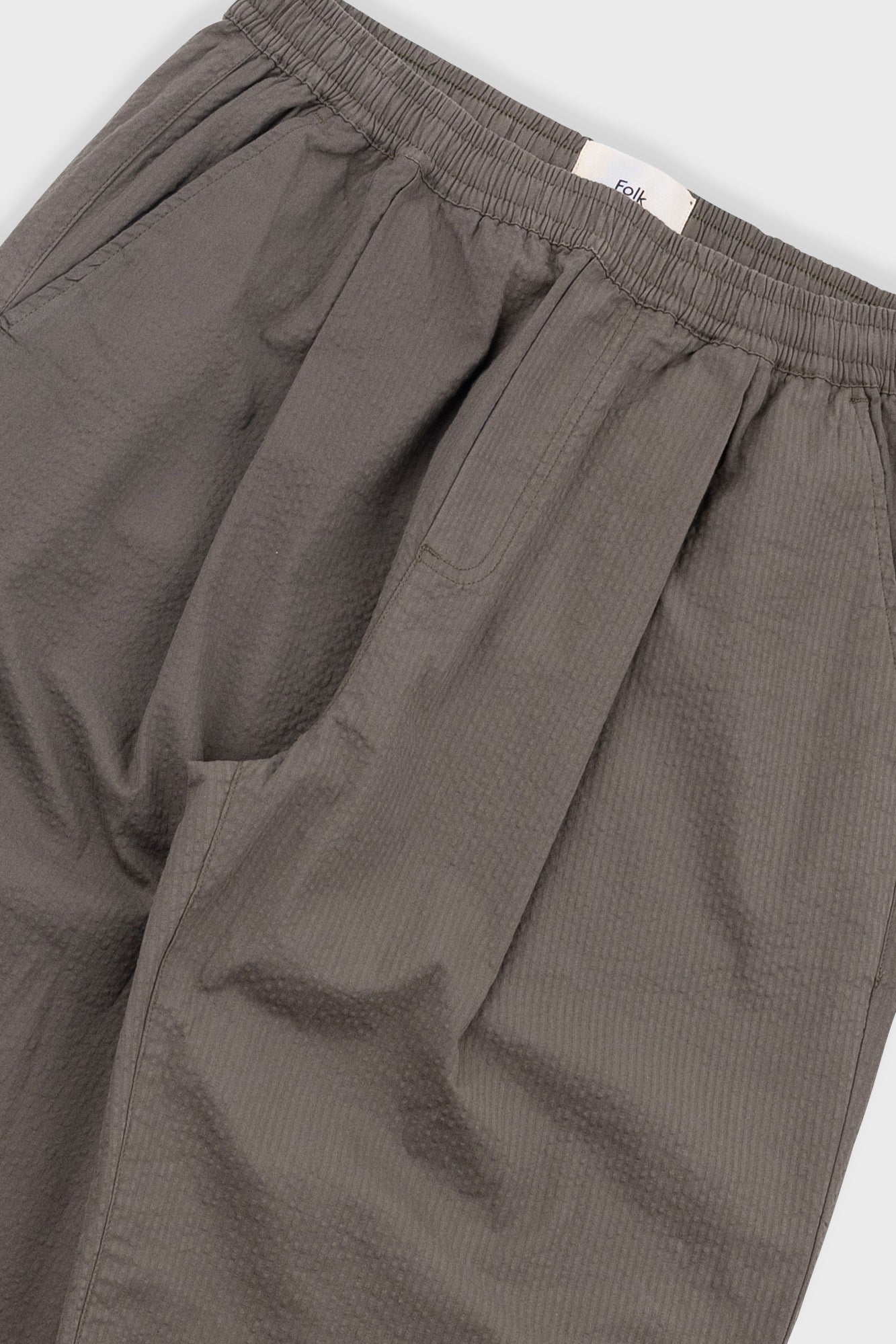 Close-up of brown pants with a white background
