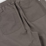 Close-up of brown pants with a visible brand logo on a white background
