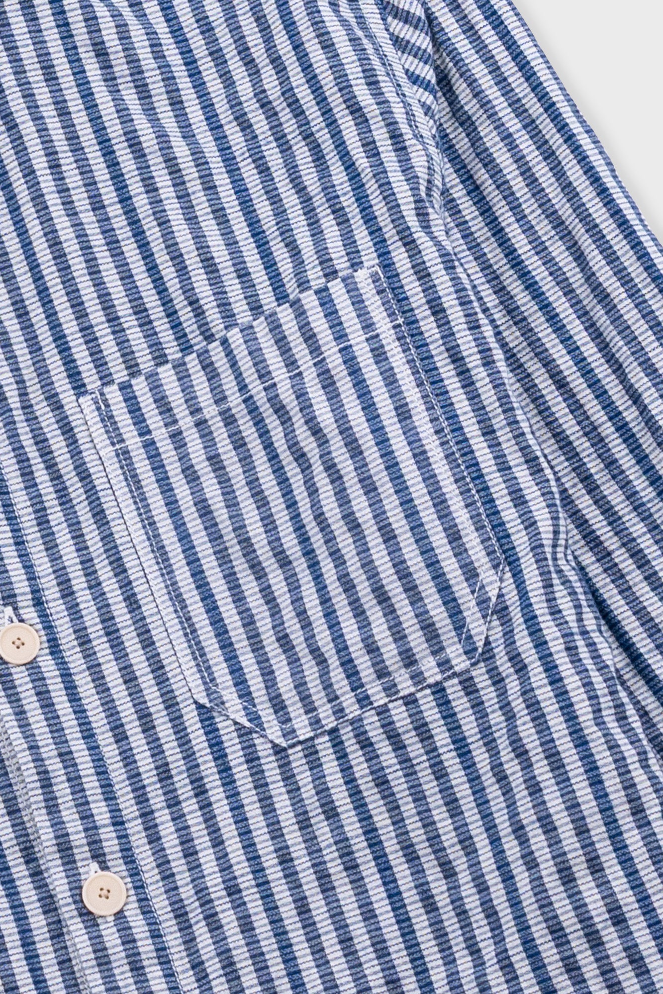 Close-up of a blue and white striped shirt with buttons.