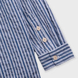 Close-up of a blue and white striped shirt with buttons on a white background