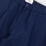 Navy blue pants with a visible brand label on a light gray background