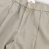 Beige pants with a visible brand label on a light gray background