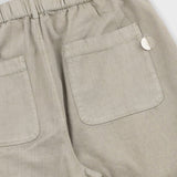 Close-up of beige pants with a pocket on a white background