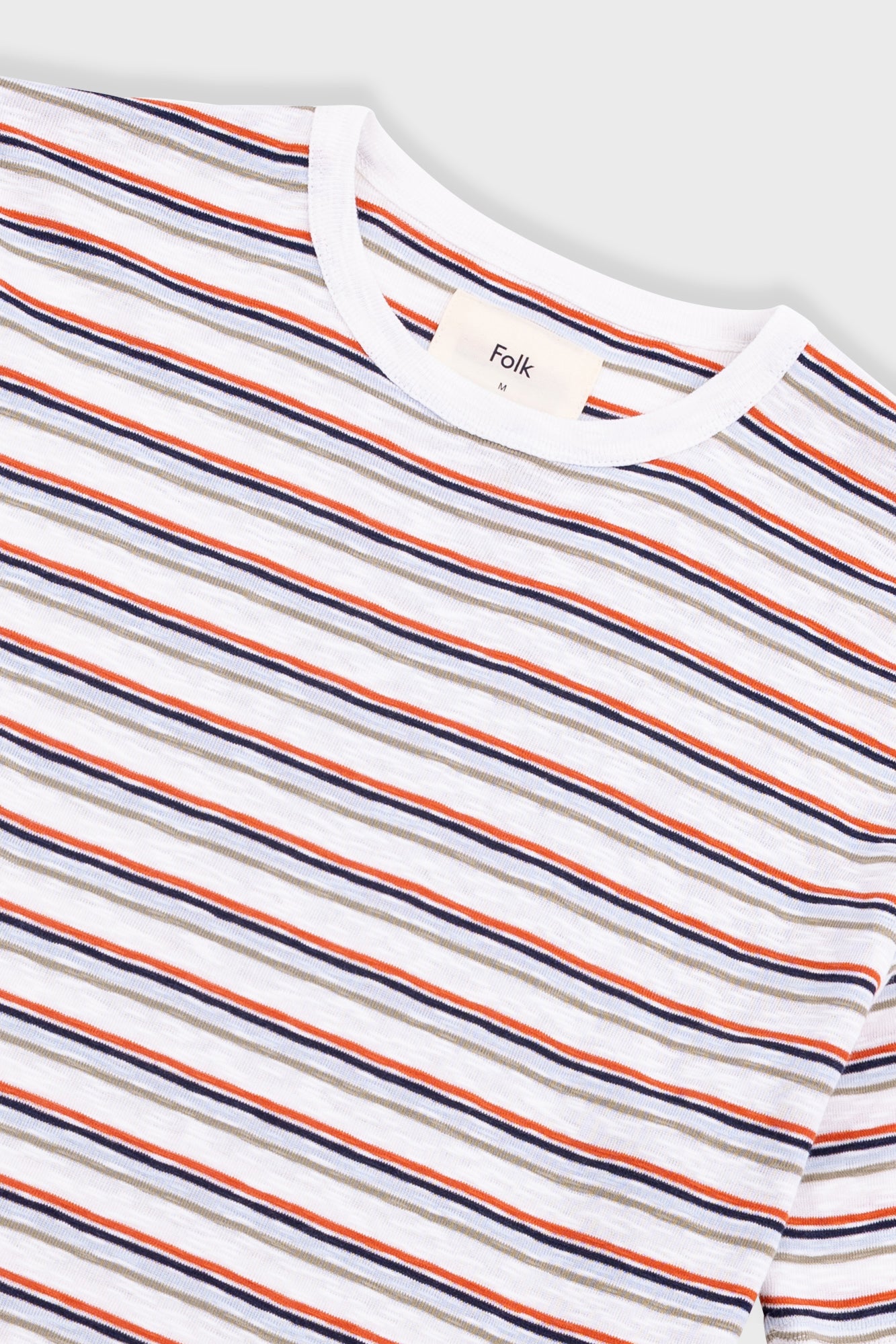 Striped t-shirt with visible brand logo on a light gray background