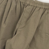 Close-up of beige pants with a white background