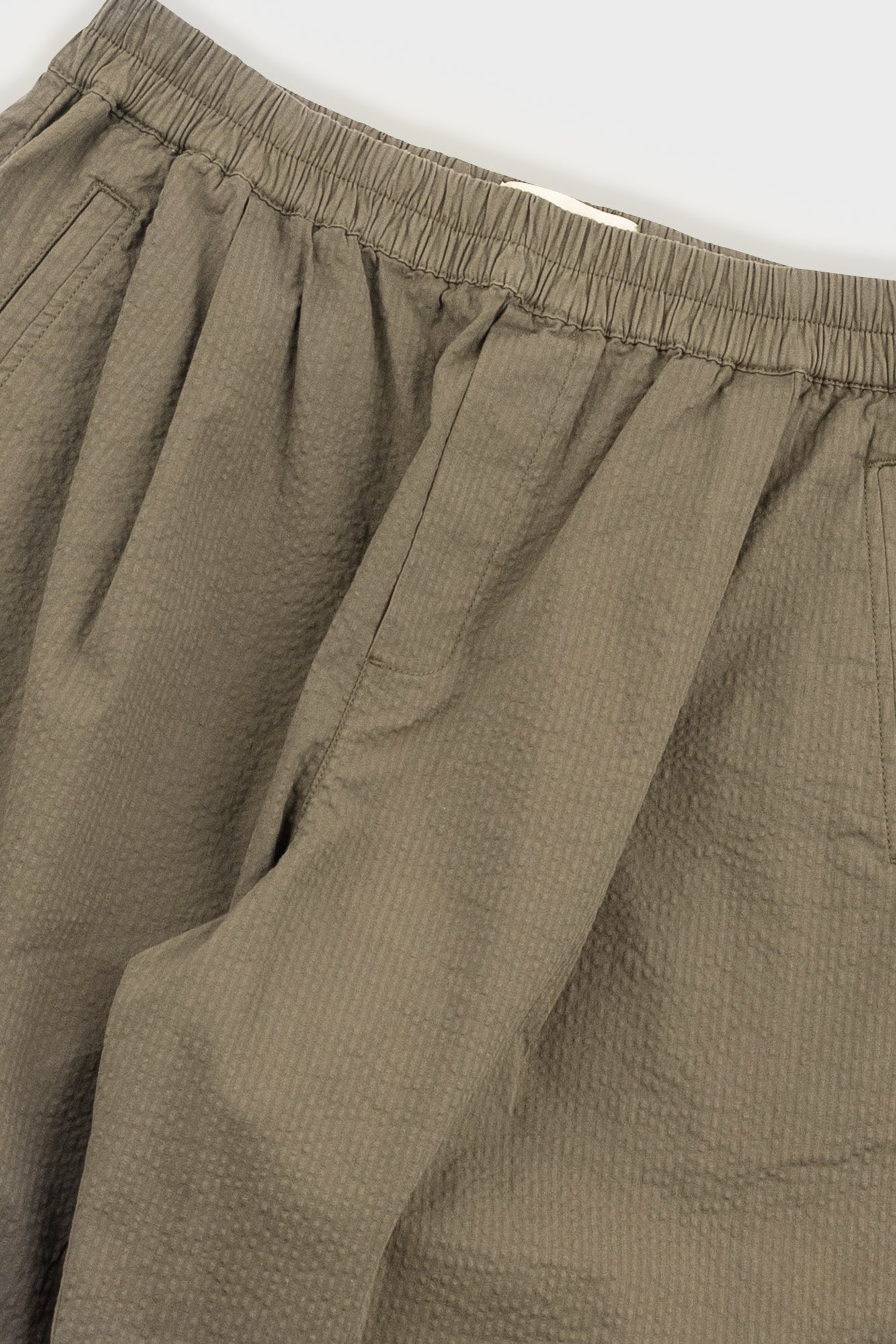 Close-up of beige pants with a white background