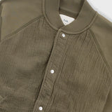Close-up of a green jacket with a brand label on a white background