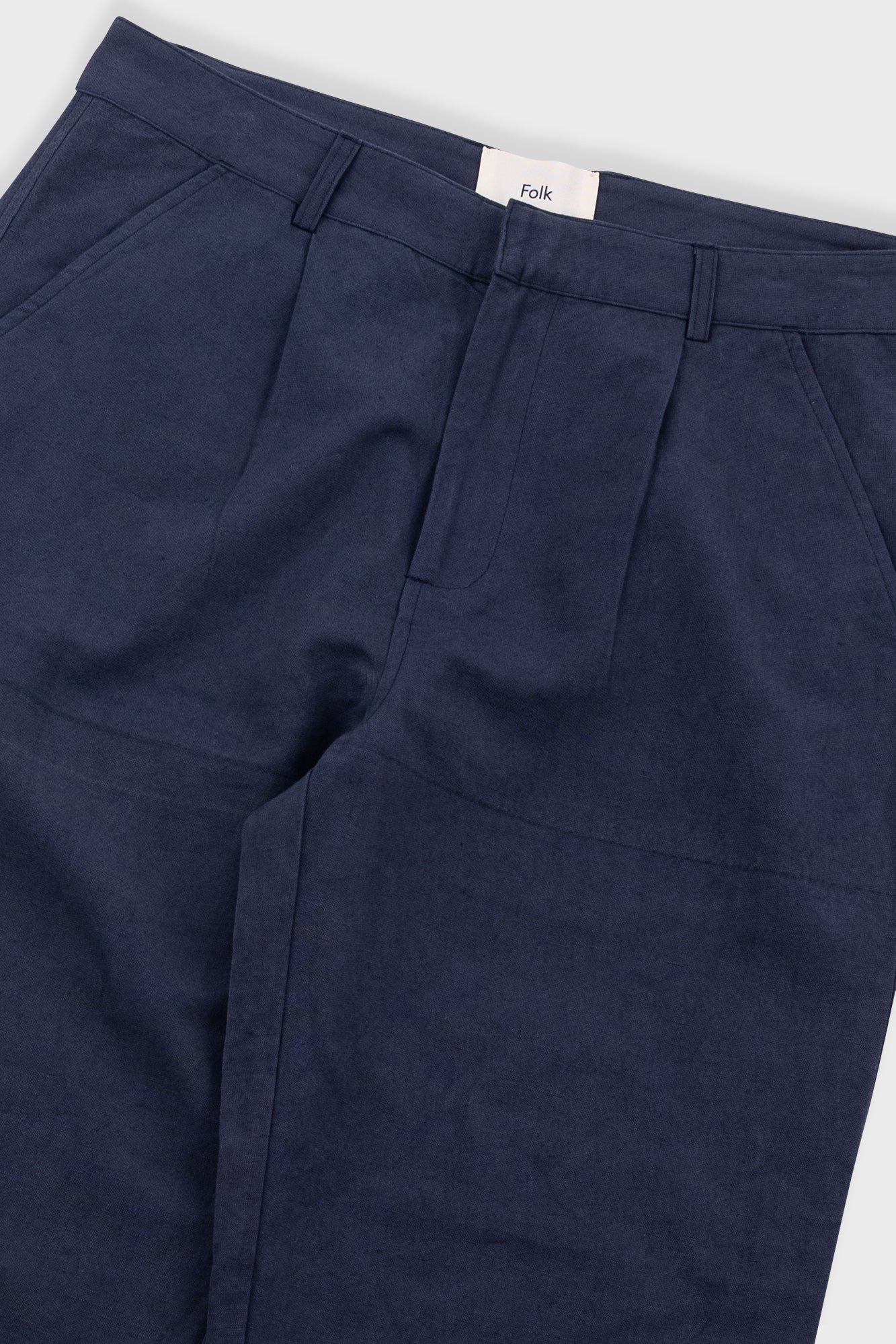 Navy blue pants with a visible brand label on a white background