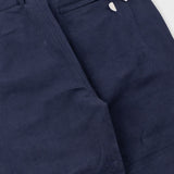 Navy blue pants with a close-up of the waistband and zipper on a white background