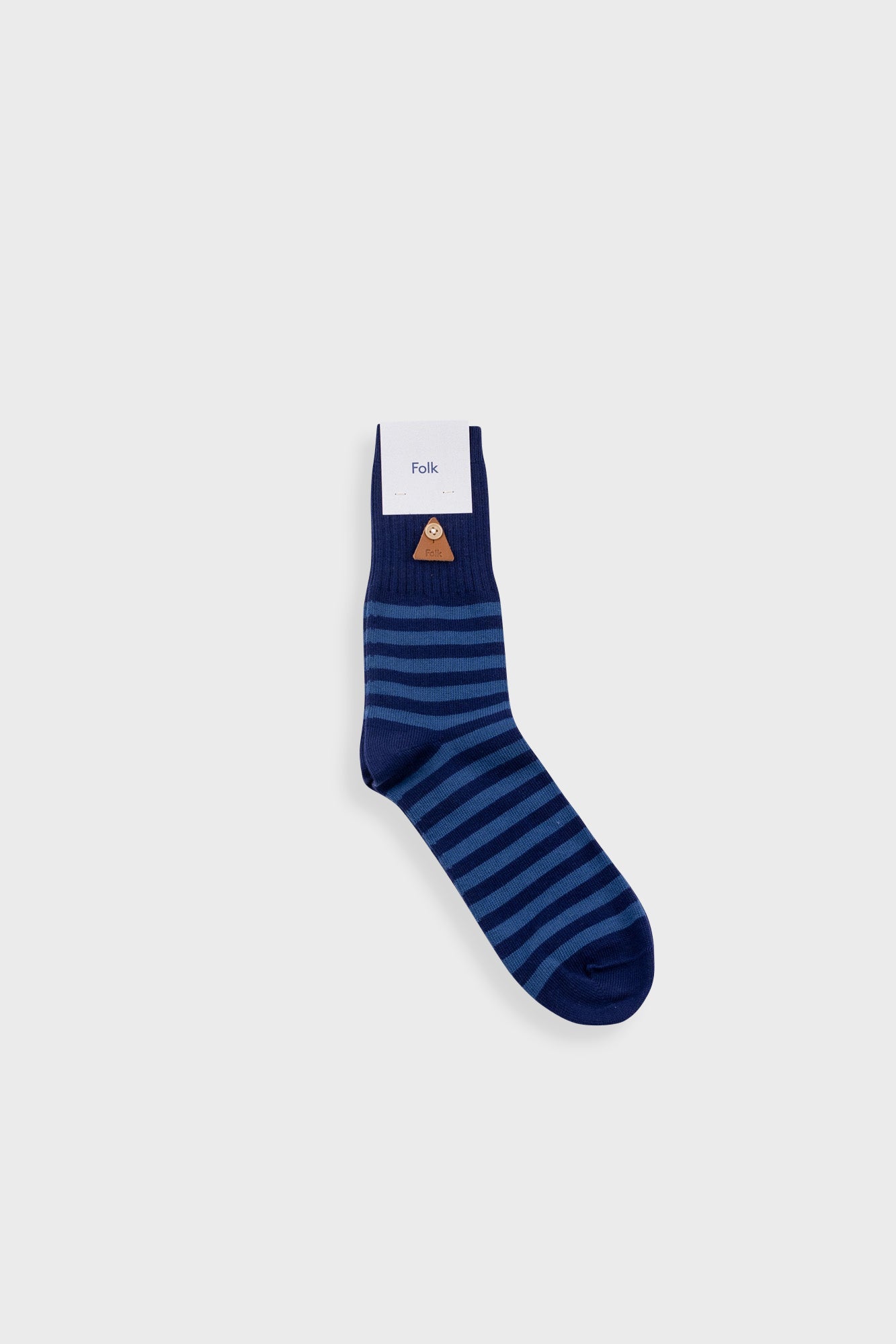 Navy and blue striped sock on grey background