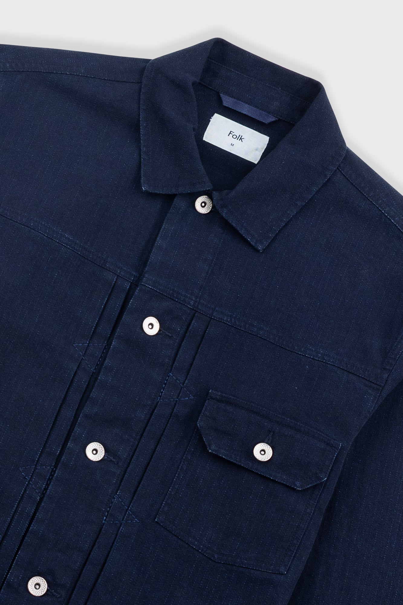 Navy blue shirt with button details on a white background