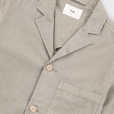 Beige blazer with brand label against light grey background