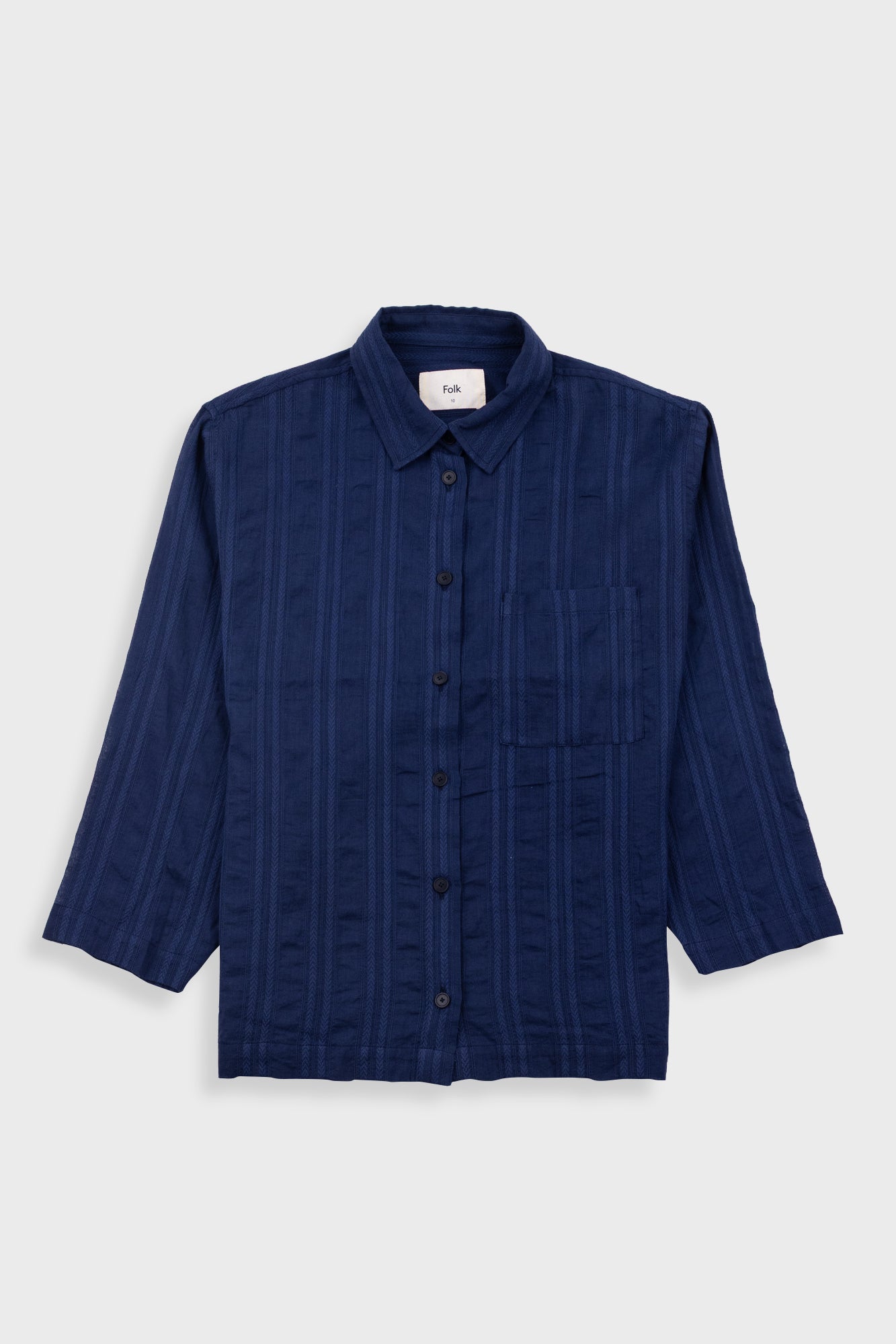 Blue textured shirt on a light gray background