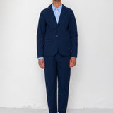 Man wearing a navy suit with a white shirt against a white background