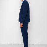 Man wearing a navy suit with a light blue shirt against a white background