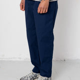 Person wearing navy pants and a striped shirt on a white background