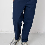 Person wearing navy pants and a striped shirt on a white background