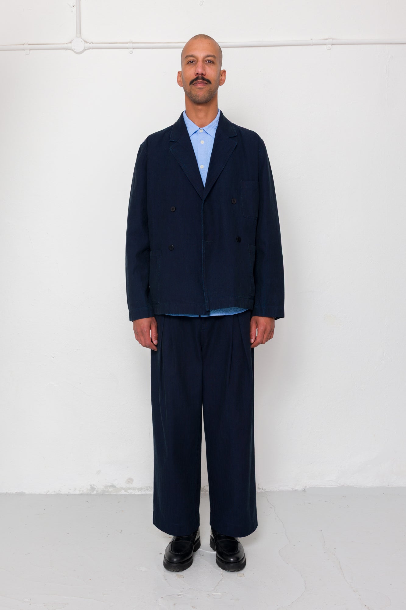 Man wearing a navy suit against a white background