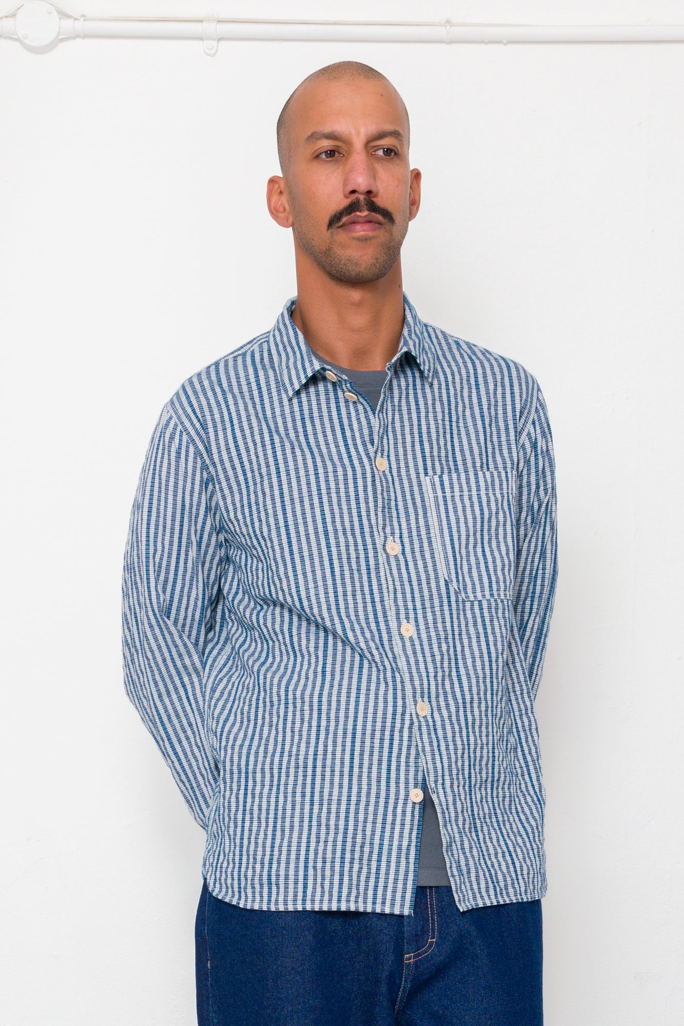 Man wearing a blue striped shirt against a white background