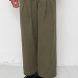 Person wearing a green suit with wide-leg pants on a white background