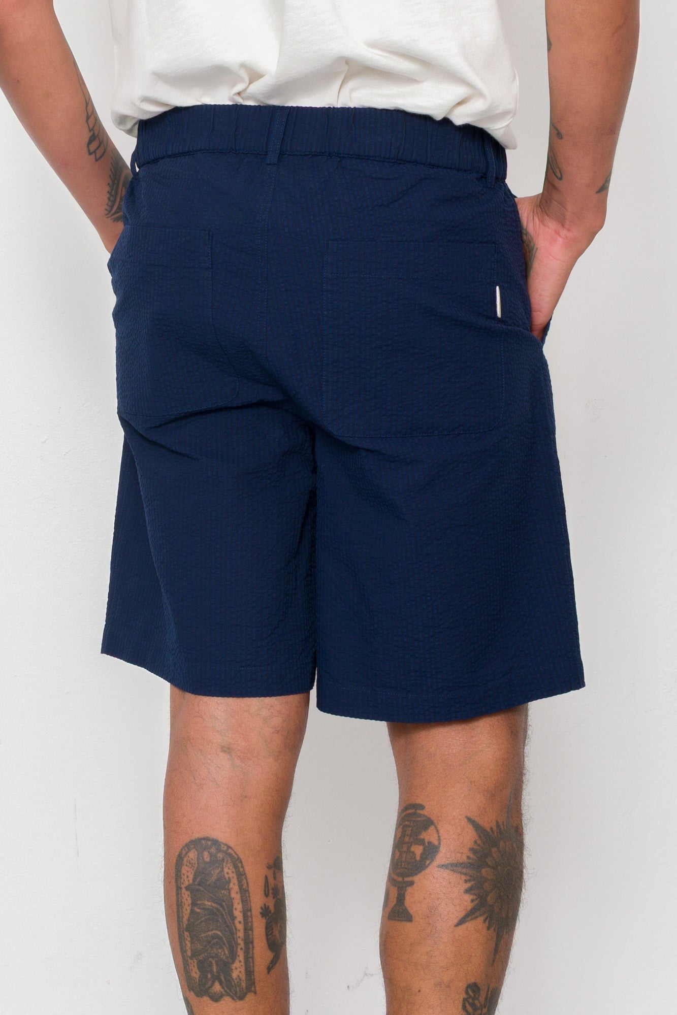 Navy shorts worn by a person on a white background