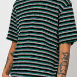 Person wearing a black and green striped t-shirt on a white background