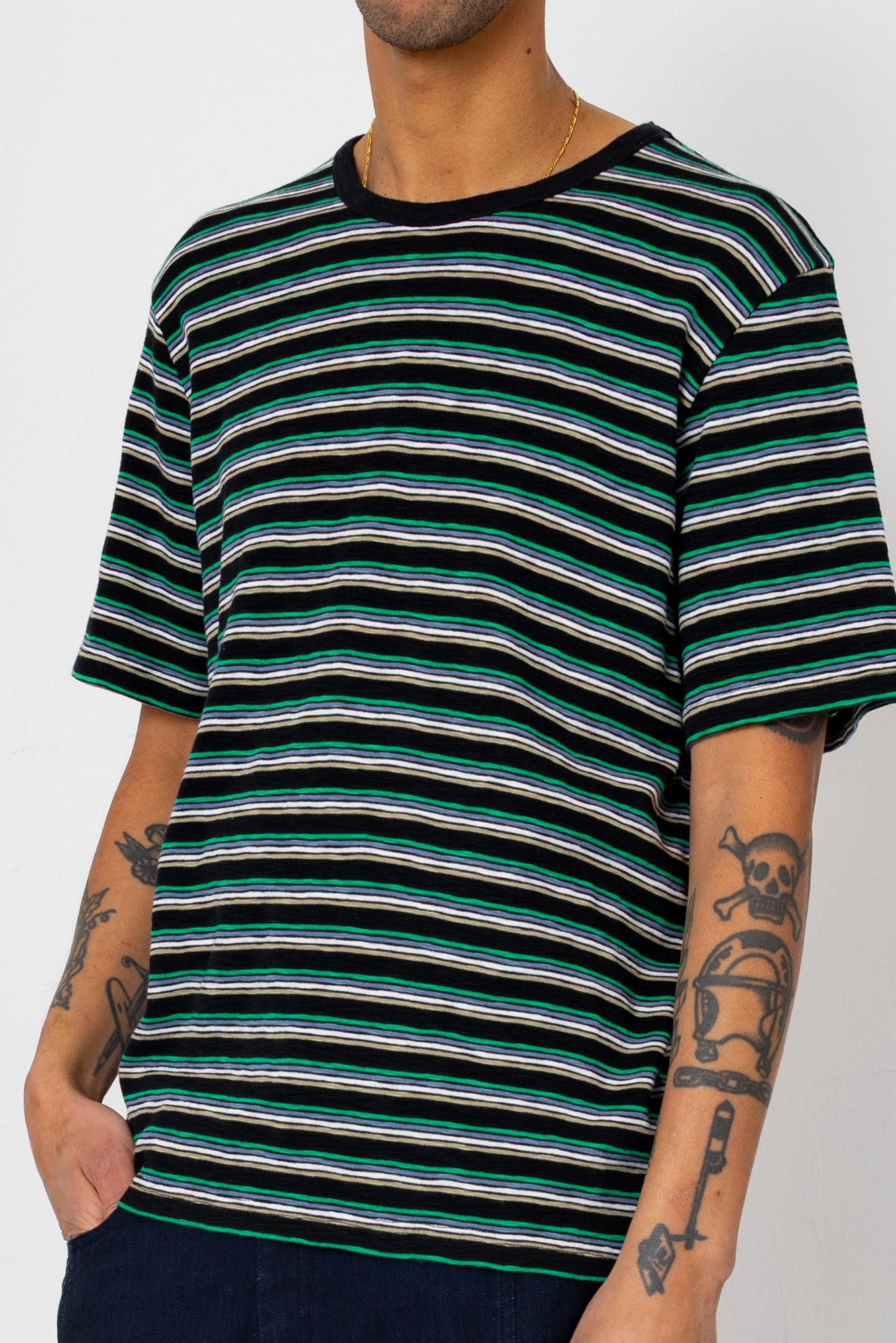 Person wearing a black and green striped t-shirt on a white background
