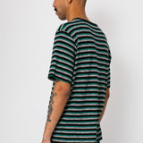 Man wearing striped t-shirt and navy shorts against light grey background