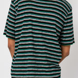 Man wearing striped t-shirt and navy shorts against light grey background