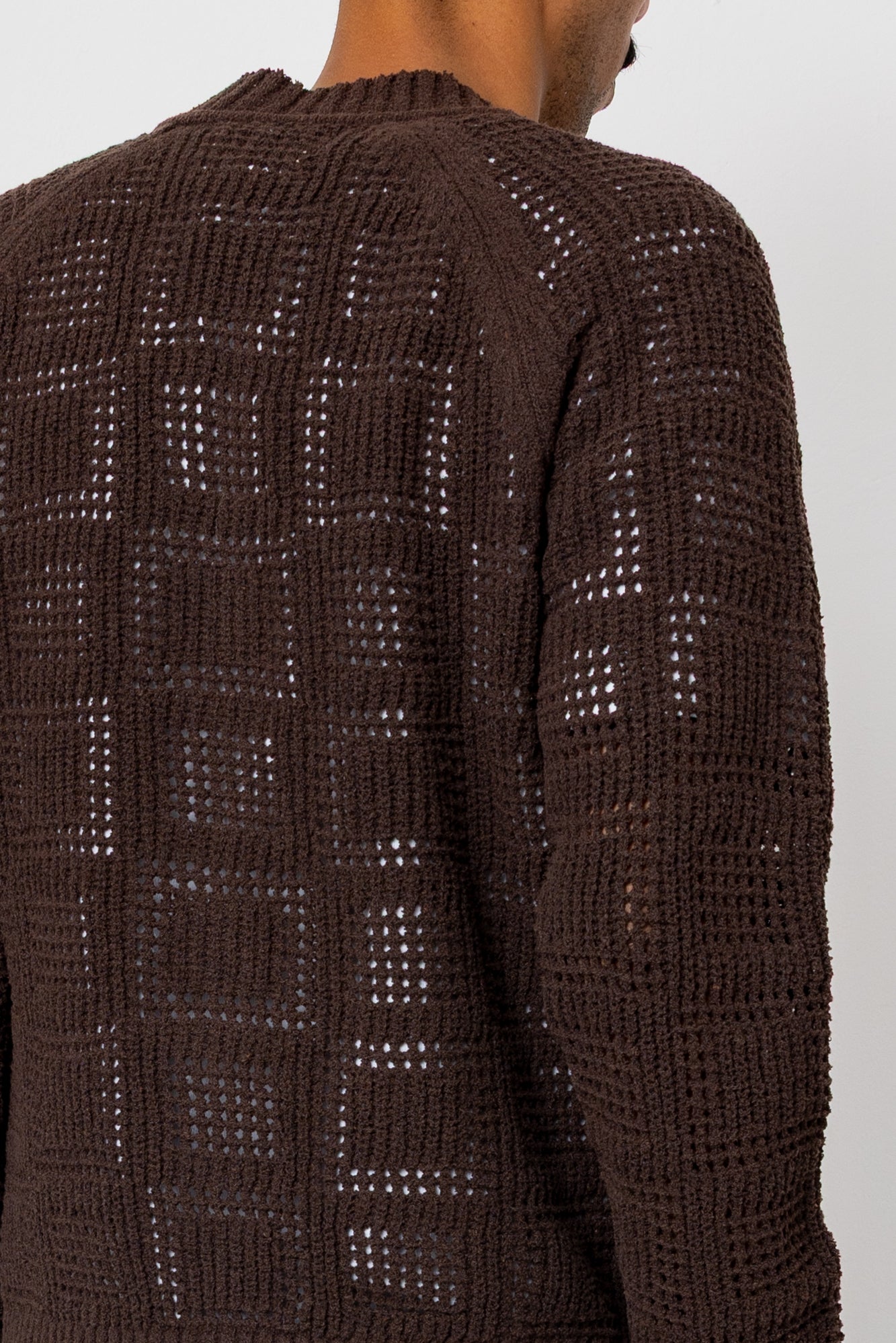 Shot showing stitch detailing of dark brown cardigan